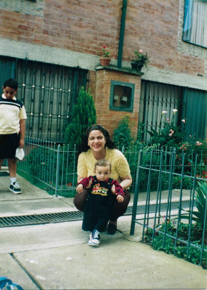 Daniel Felipe Montenegro as a small child, held by his mother Paola as she crouches in the front garden of the house; his uncle Juan Pablo stands behind them