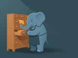 An elephant in an apron pulling an index card from a wooden card-catalogue drawer